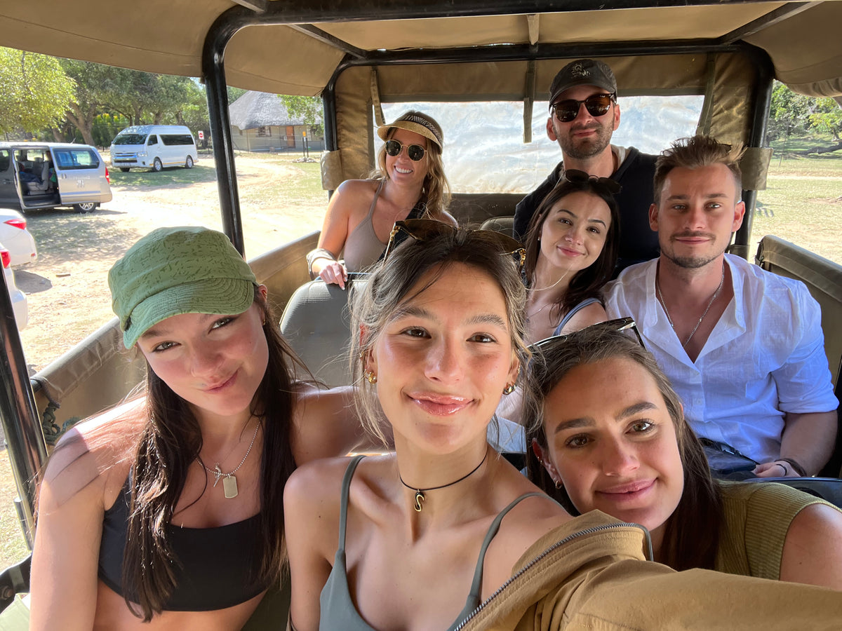 Five people in a safari car with a scenic background in south africa