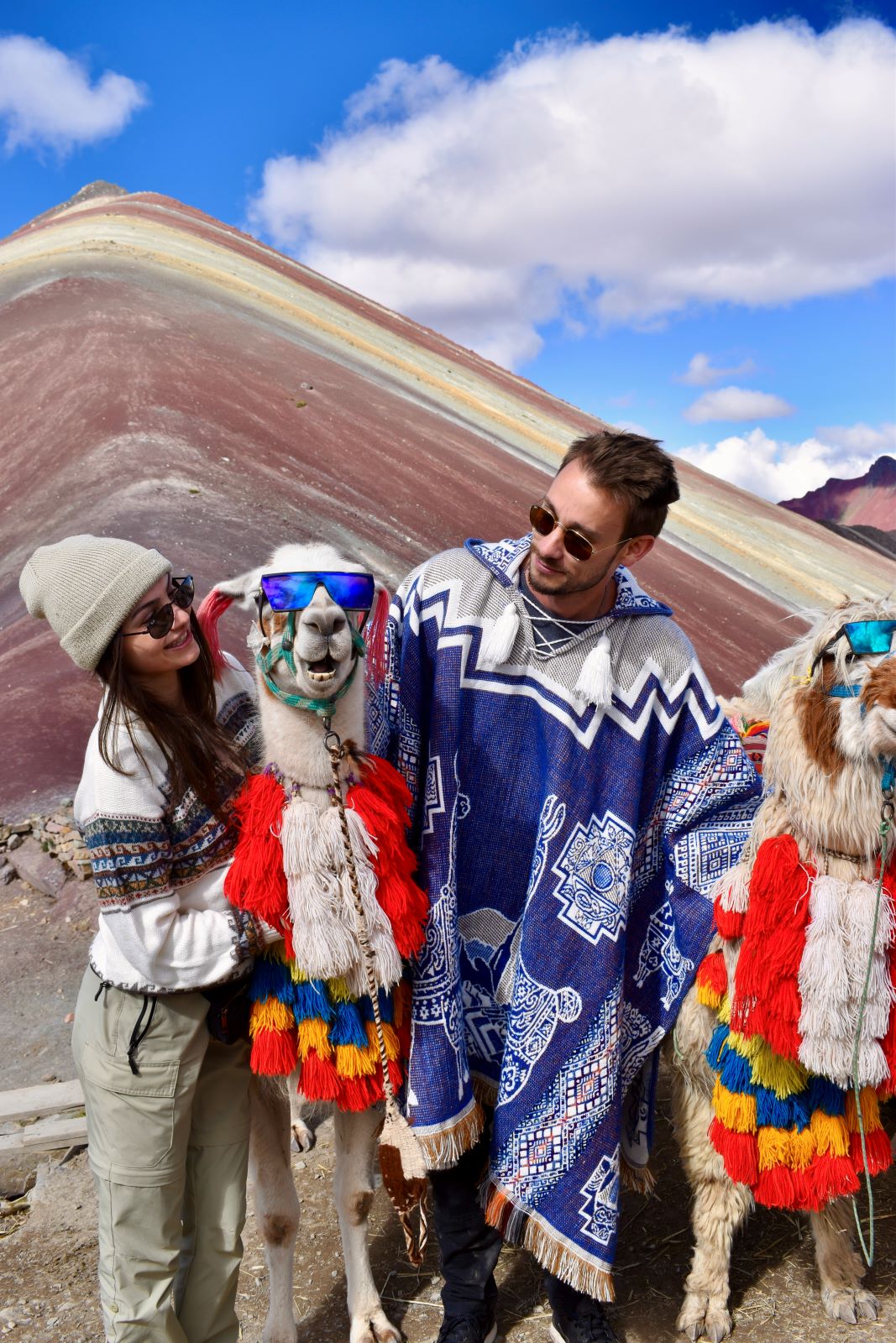 Two people with llamas at Rainbow Mountain in Peru