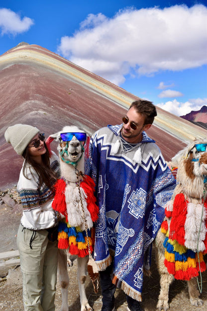 Two people with llamas at Rainbow Mountain in Peru