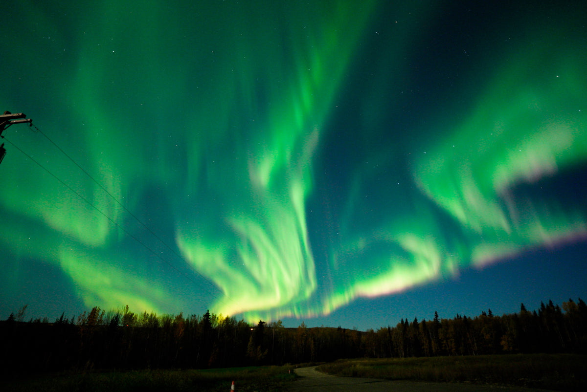Bright green Northern Lights sweeping across the Alaskan night sky